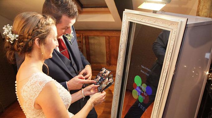 A wedding couple comparing pictures from the Magic Mirror